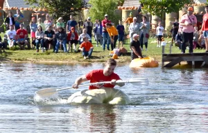 Männlicher Teilnehmer paddelt angestrengt im Kürbis-Boot auf der Krewelshofer Kürbis-Regatta.